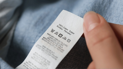 A person reading a care label on a pair of jeans